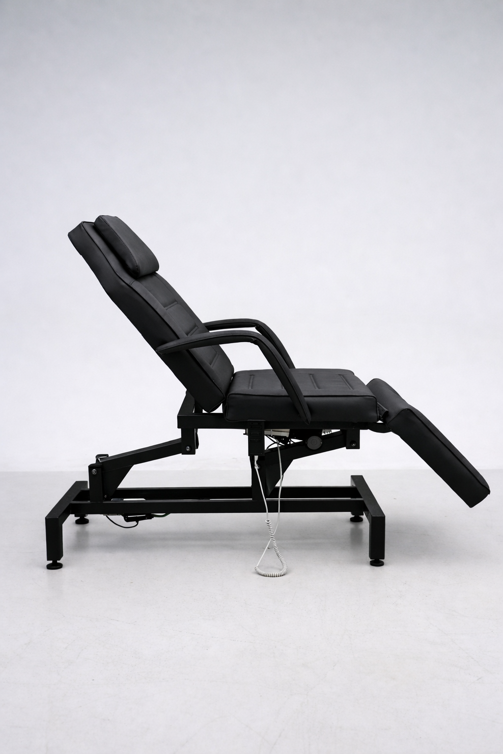 Electric cosmetic treatment chair in black upholstery with ergonomic design for clinics, med spas and salons
