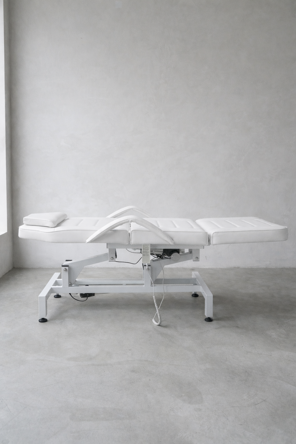 Electric clinic beauty bed in white upholstery with ergonomic armrests and multi-position reclining design