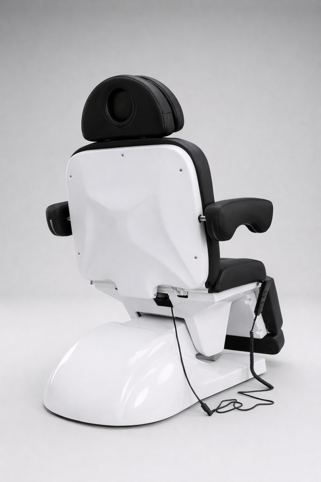 Modern black salon bed with padded headrest, reclining backrest, and adjustable leg rest for client comfort