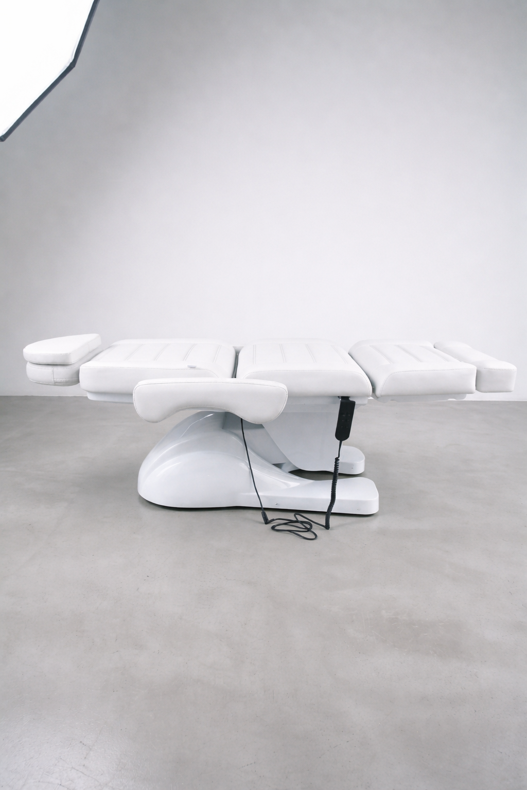 Salon treatment bed with white upholstery, powered height and recline adjustment, ideal for facials, lashes, and cosmetic services