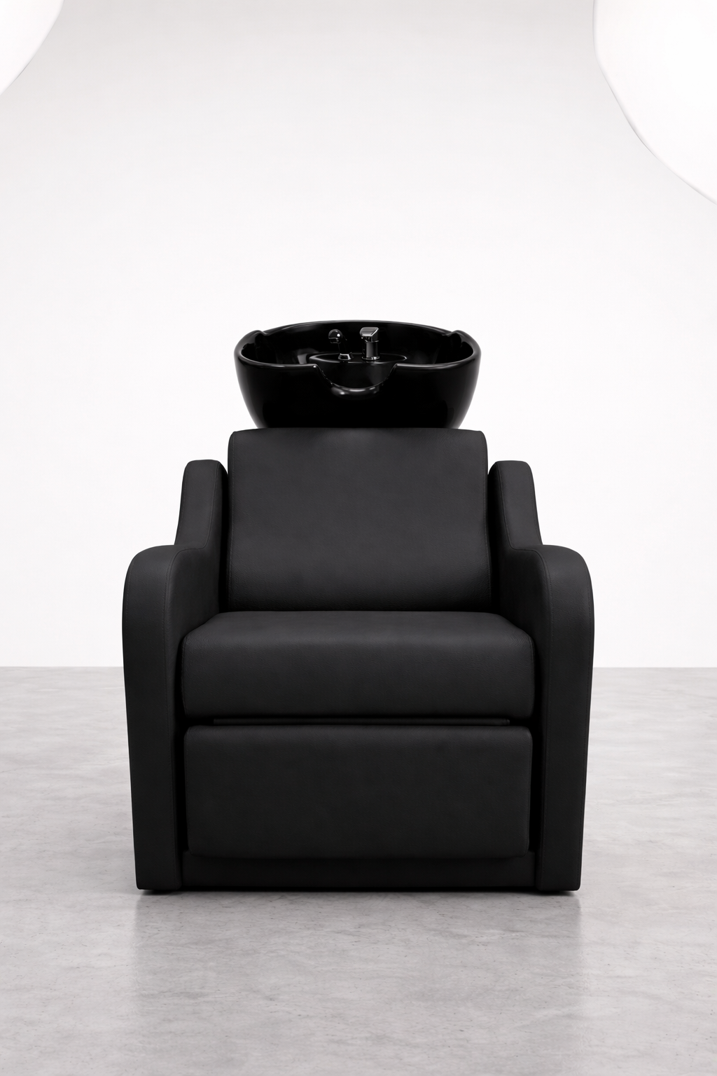 Salon wash chair with matte black vinyl finish, cushioned seating, and built-in white sink, ideal for commercial hairdressing setups