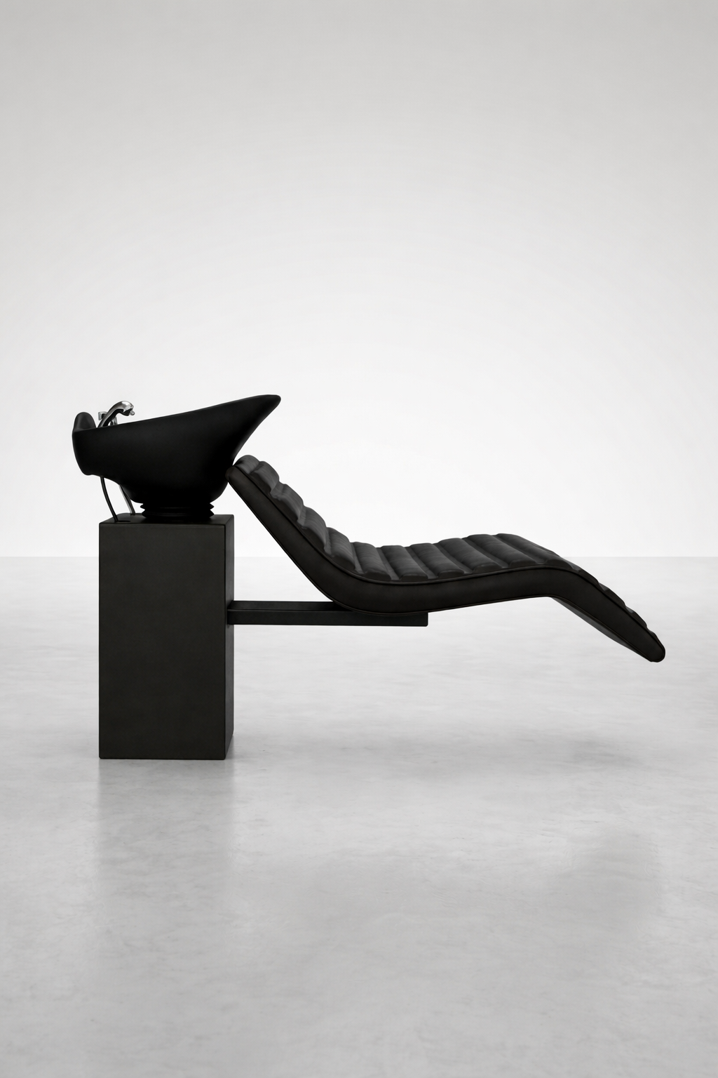 Sleek black wash basin chair featuring padded recliner and matte base, professional salon backwash unit