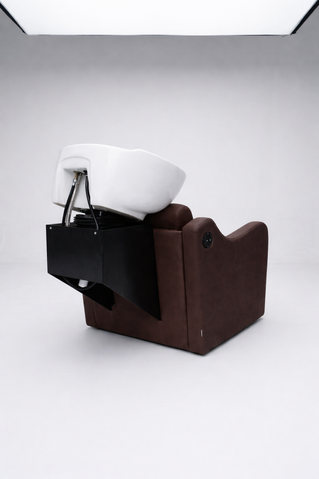 Ergonomic shampoo station chair in chocolate brown vinyl with reclining backrest and ceramic basin, designed for professional salons