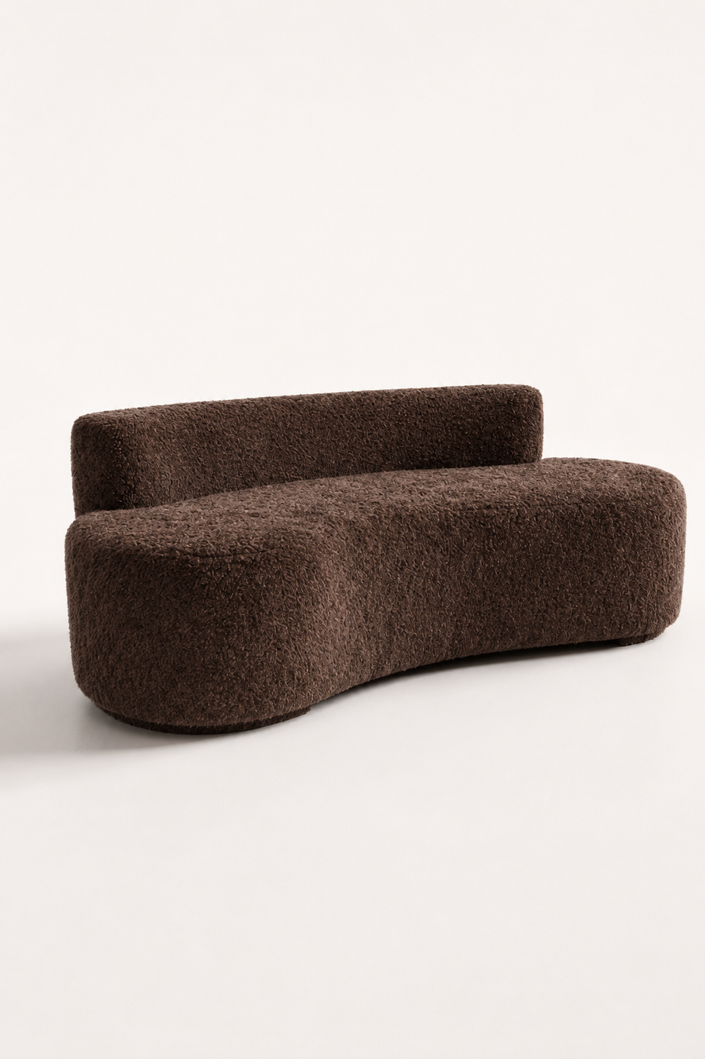 A modern curved upholstered bench or sofa in a dark brown bouclé fabric, photographed on a clean off-white studio background.